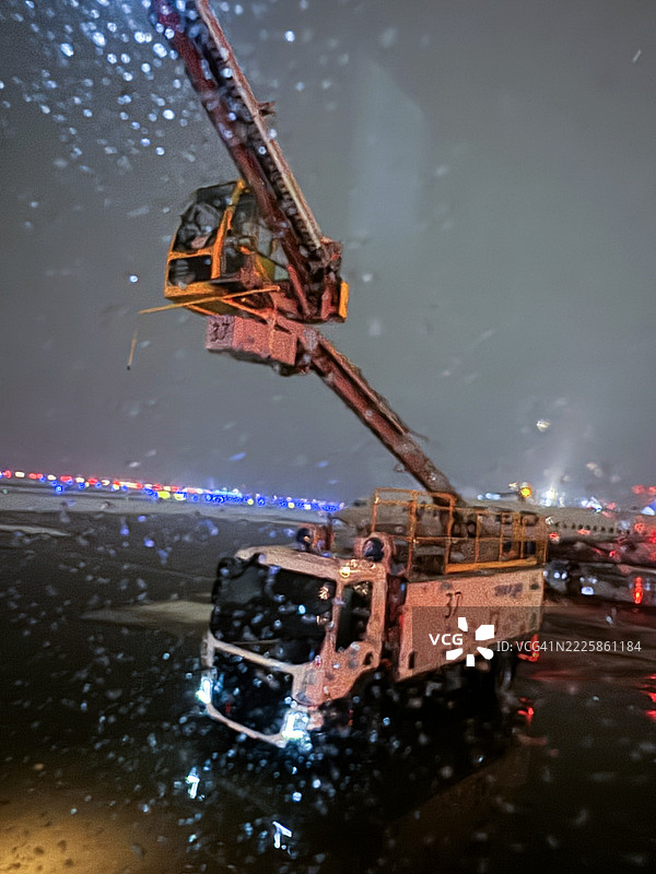 夜间的机场除冰机-竖版图片素材