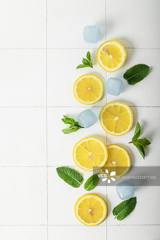 新鲜柠檬和薄荷叶在白色瓷砖背景上 - 夏季清爽概念图片素材