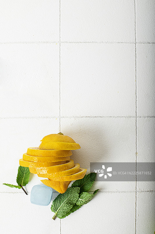 新鲜柠檬和薄荷叶在白色瓷砖背景上 – 夏季清爽概念图片素材