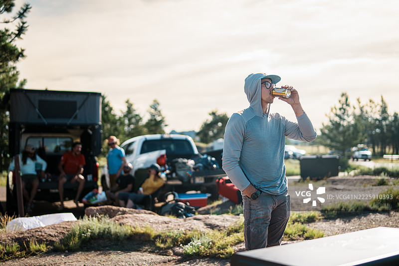 男人在露营地与朋友们一起喝啤酒图片素材
