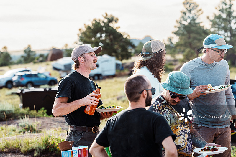 朋友们在露营地享用晚餐图片素材