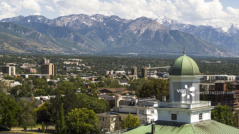 瓦萨奇山脉勾勒出盐湖城市天际线，历史悠久的市议会大厅的铜顶熠熠生辉。图片素材
