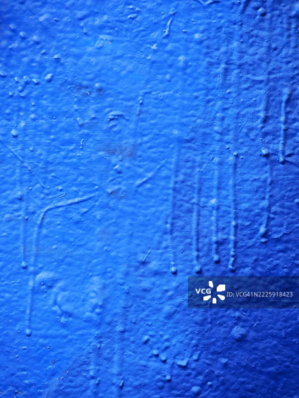 涂有蓝色油漆的混凝土墙，带有干燥的滴痕。纹理粗糙。阳光。自然色调。法国巴黎。全画幅 4:3图片素材