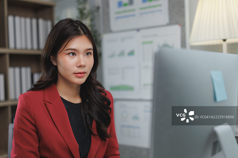 专注的亚洲女商人在现代办公室里使用电脑图片素材