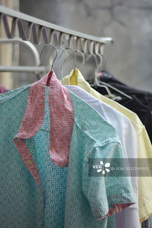 五颜六色的衬衫和裤子翻面挂在晾衣架上晾晒在户外图片素材