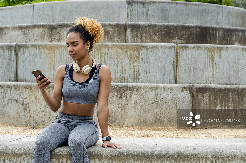 运动型年轻女性使用手机图片素材