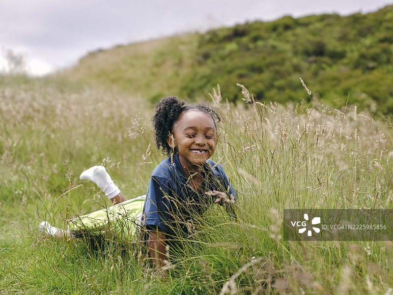 微笑的女孩躺在草地上图片素材