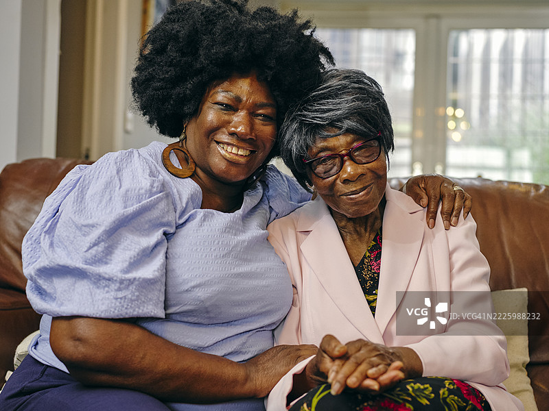 成熟的女性在沙发上拥抱年长母亲的肖像图片素材