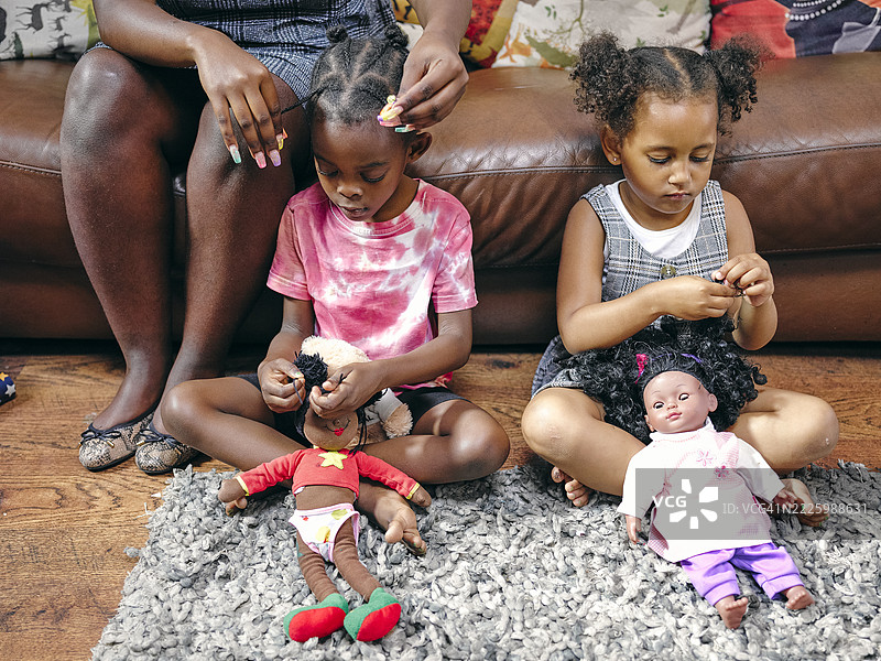 女孩们坐在地板上玩洋娃娃图片素材