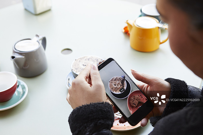 女人使用智能手机拍摄食物照片图片素材
