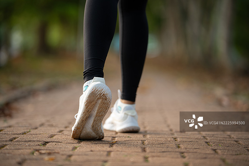跑鞋。女性脚部特写在路上跑步。女性运动健身者准备在户外慢跑。跑步锻炼的动力与健康与健身。图片素材