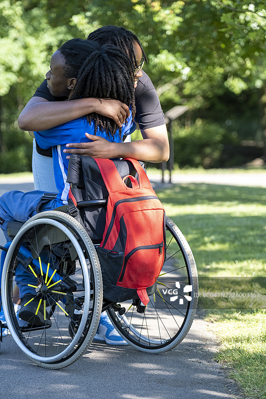 公园里坐在轮椅上的少女（16-17岁）与朋友见面图片素材