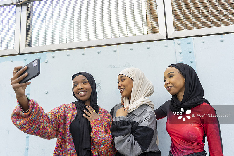 微笑的年轻女性戴着头巾自拍图片素材