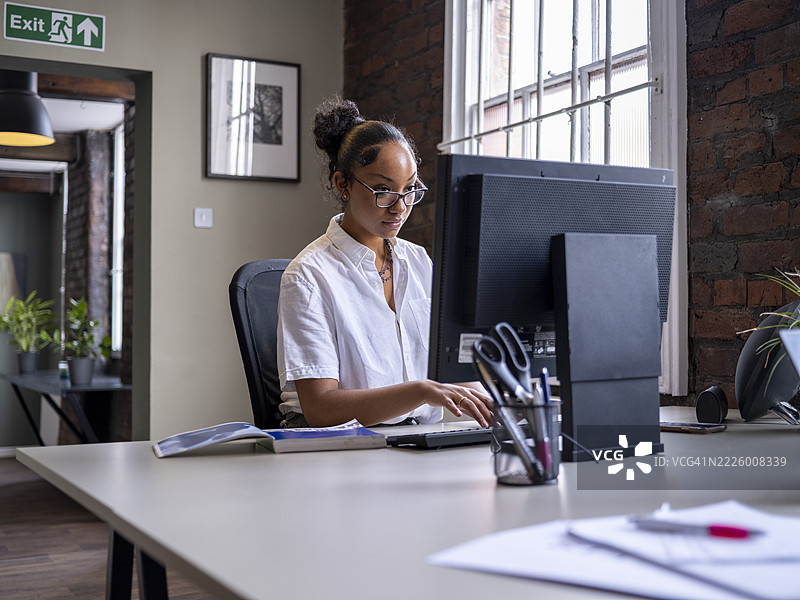 办公室里使用电脑的16-17岁女孩图片素材