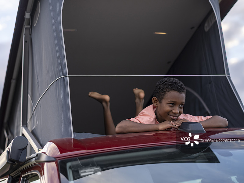 男孩（8-9岁）在房车的顶篷帐篷里图片素材