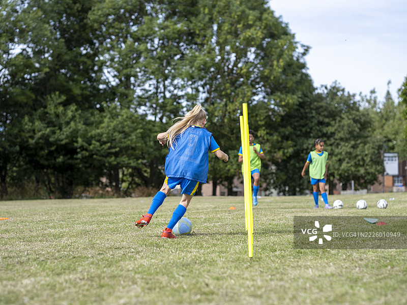 穿着校服的孩子们（8-9岁）在足球场上练习图片素材