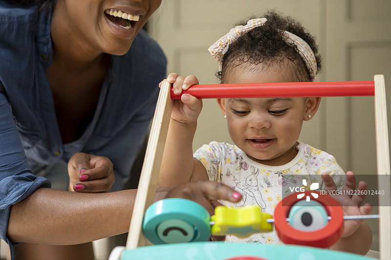母亲在家里和12到17个月大的女儿玩耍图片素材