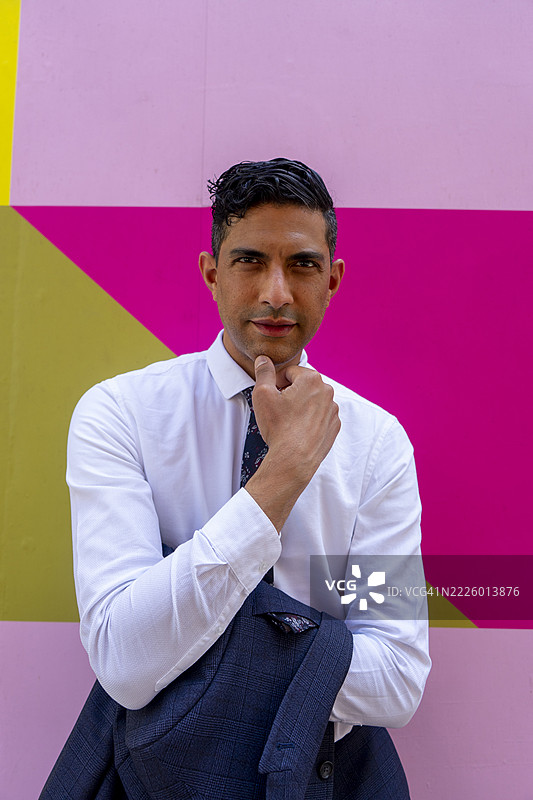 商人站在色彩斑斓的墙前的肖像图片素材