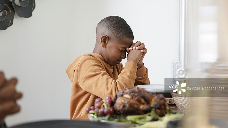 男孩（8-9岁）在宽扎节餐前祈祷图片素材
