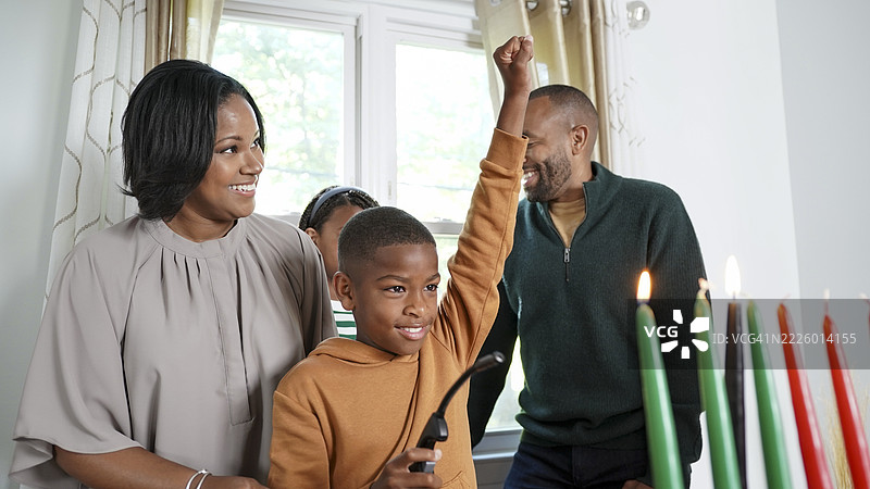 一家有孩子（8-9岁，12-13岁）正在点燃基纳拉蜡烛图片素材
