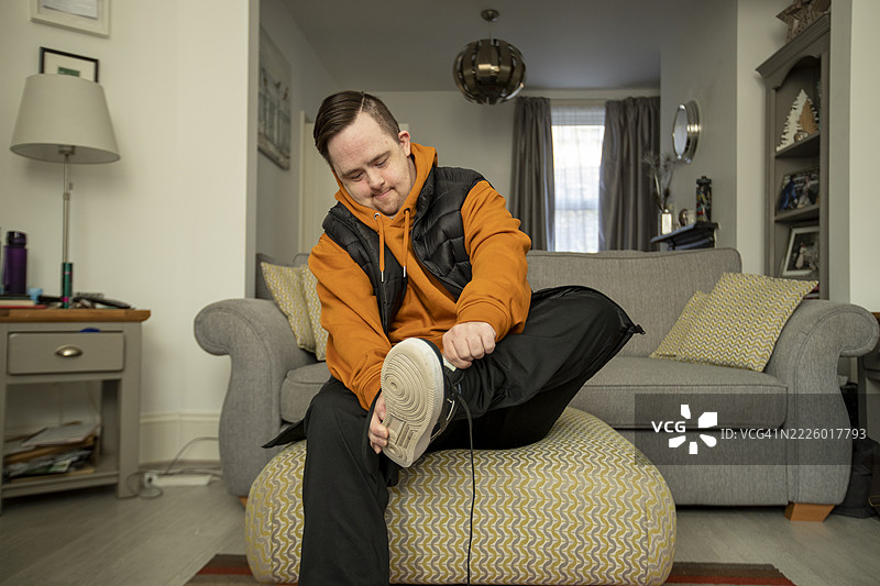 男人坐在客厅里穿衣服图片素材