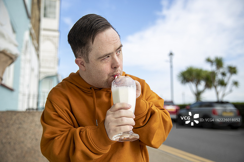 男人在街边咖啡馆喝奶昔图片素材