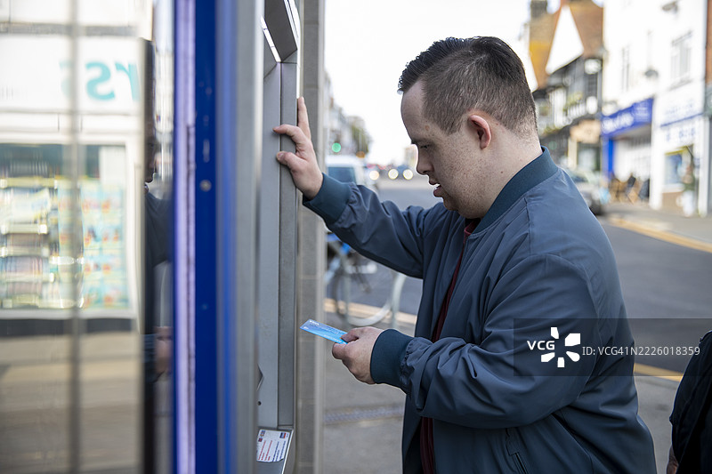 男子在街上使用自动取款机图片素材