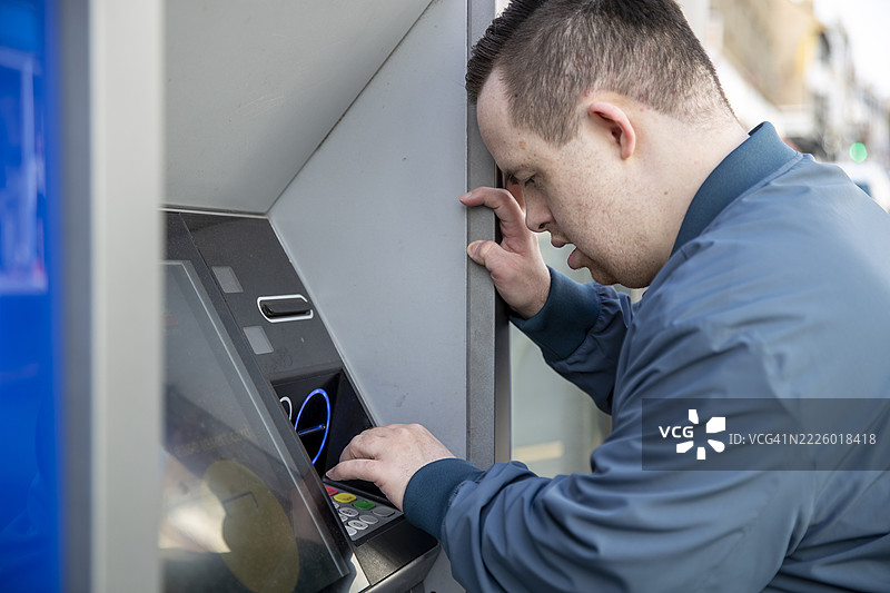男子在街上使用自动取款机图片素材