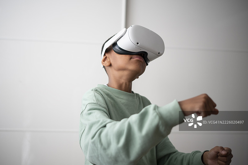 男孩在家中使用虚拟现实头盔图片素材