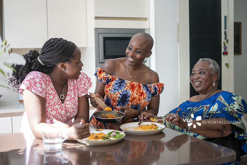 少女与母亲和祖母在餐桌上共进晚餐图片素材