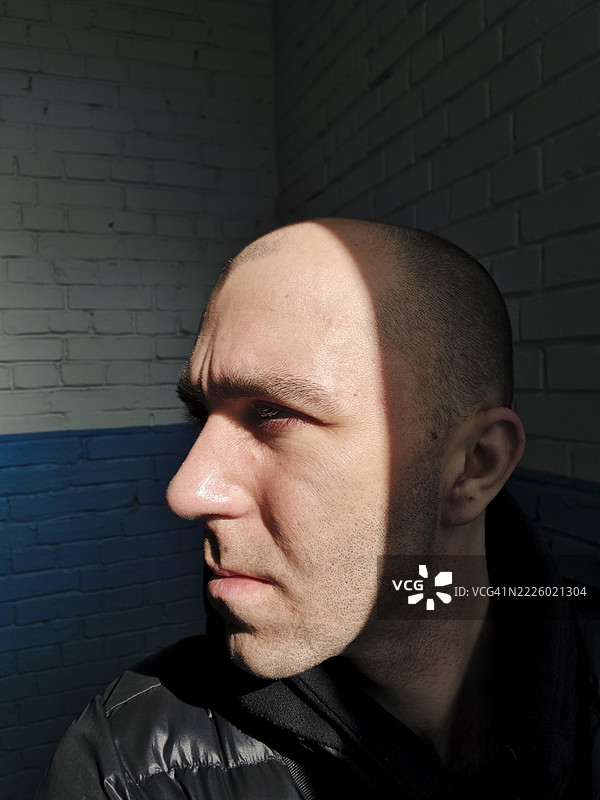 剃光头的男人侧面严肃地看着远方图片素材