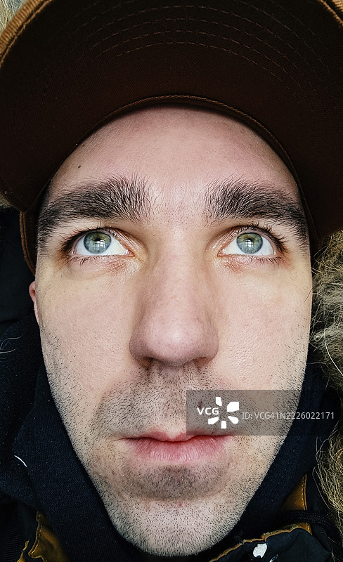 沉思的男子戴着帽子，满怀希望和期待地仰望。图片素材