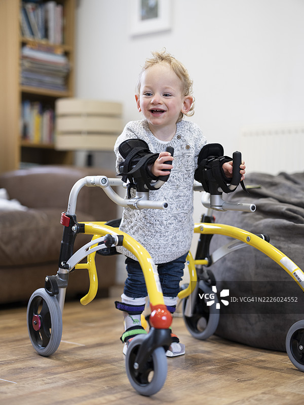 患有脑性瘫痪的男孩使用助行器行走图片素材