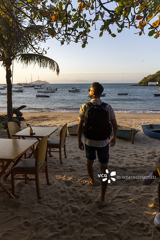 背影男士背着背包在海滩上图片素材