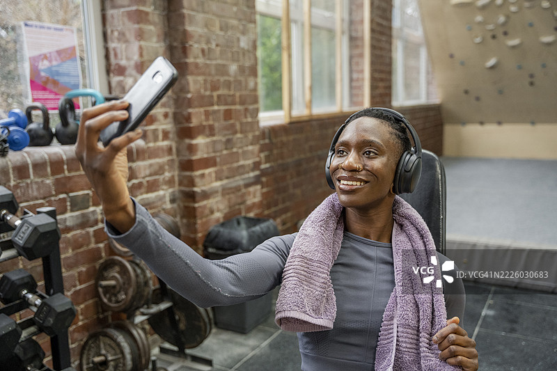 微笑的运动女性在健身房自拍图片素材