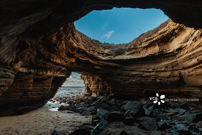 海洞入口，俯瞰天空和海岸岩石 formations图片素材
