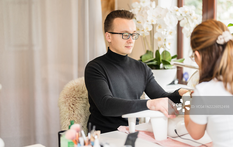 男子在接受专业美甲护理时放松身心。图片素材