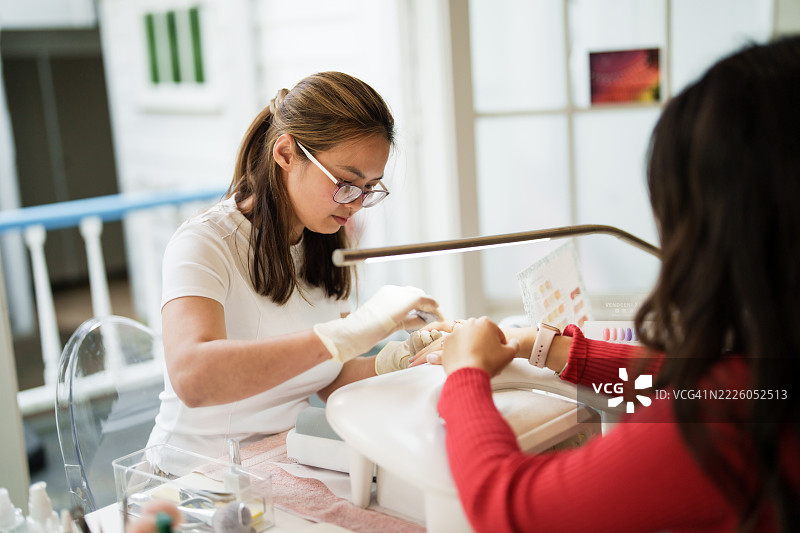 美容院的女性客户进行美甲护理。图片素材