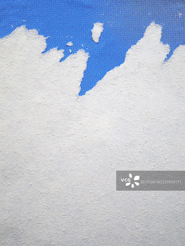 撕裂的黑白海报贴在墙上，带有粗糙的纹理，阳光照射，色彩自然。法国巴黎。图片素材