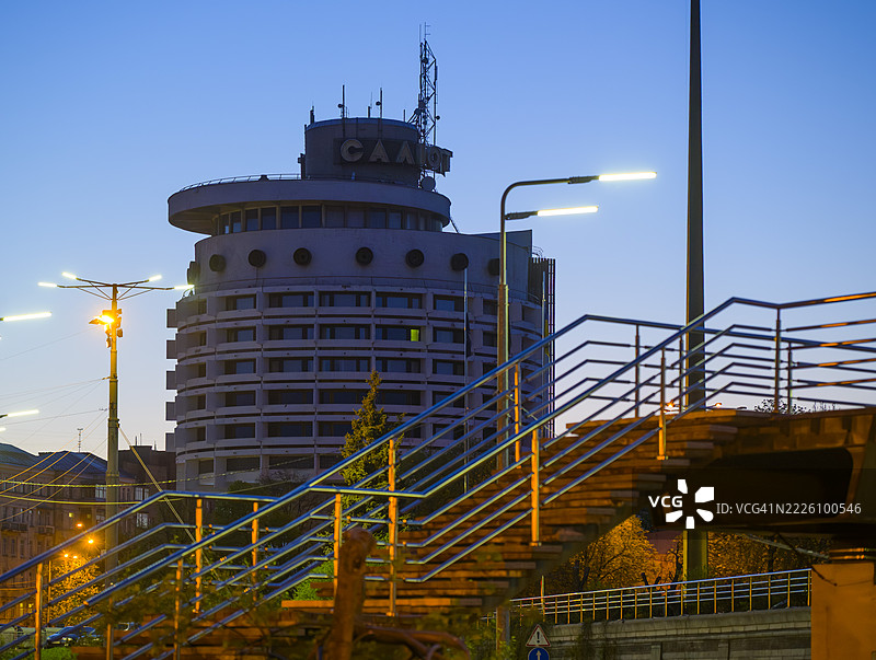 基辅黄昏时分的萨卢特酒店，前景是现代金属人行天桥图片素材