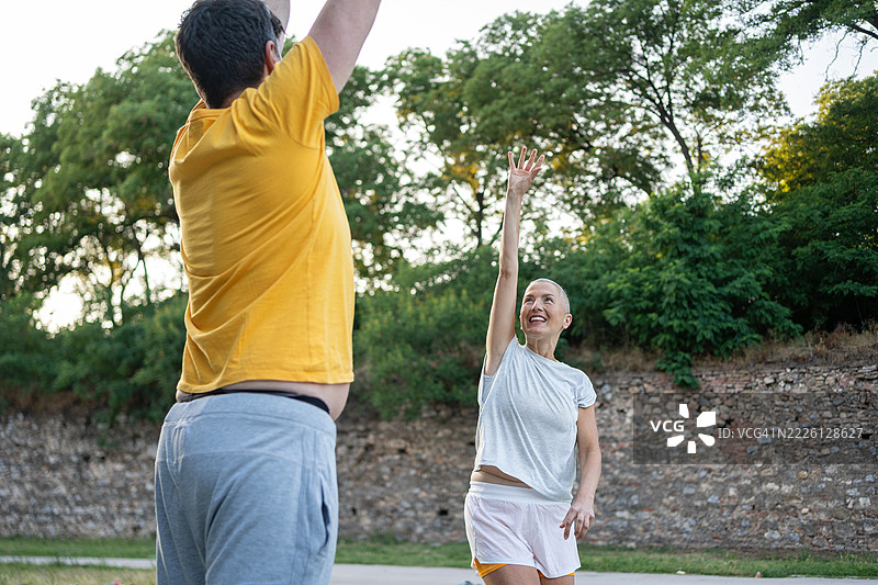 中年夫妇在阳光明媚的日子里户外打篮球图片素材