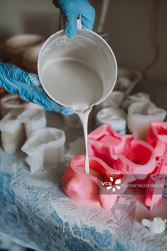 在工作室中将液体倒入模具以制作艺术雕塑图片素材