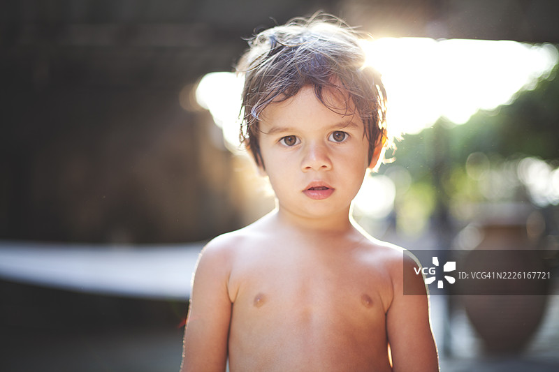 年轻男孩在温暖的阳光下面露严肃表情图片素材