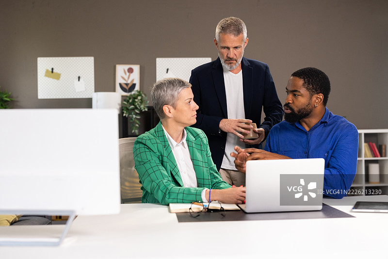 商务团队在现代办公室使用笔记本电脑协作项目图片素材