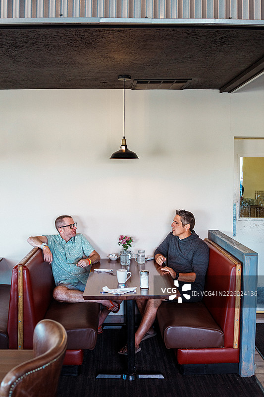 两个男性朋友在餐馆一起吃早餐图片素材