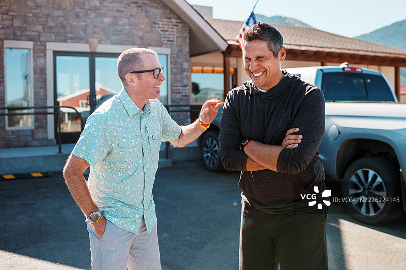 在美国乡村小镇的餐馆停车场里交谈的朋友们图片素材