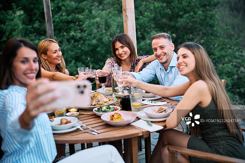 朋友们在风景如画的大自然中庆祝午餐并拍自拍照图片素材
