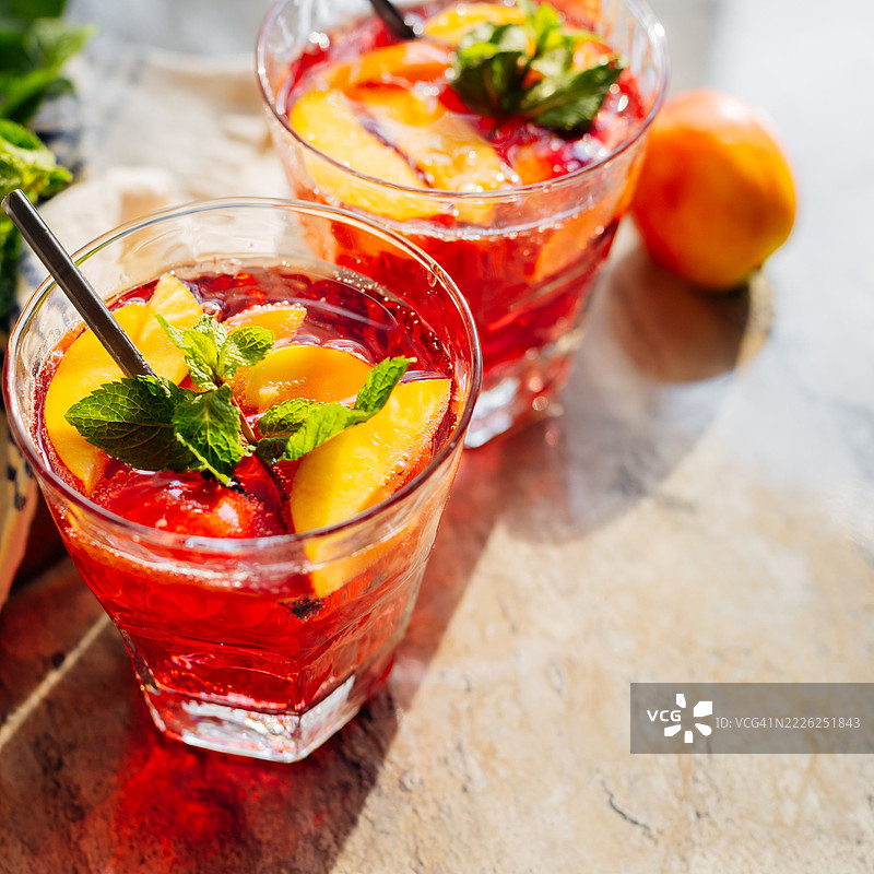 夏季冷桃鸡尾酒或薄荷冰茶，背景为大理石。自制水果冰茶，俯视角度，留有空白空间。图片素材