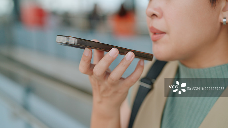 亚洲女性在站台上等火车时使用人工智能应用程序图片素材