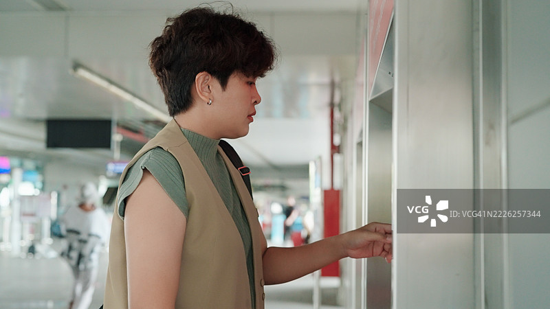 亚洲女性在售票机购票图片素材